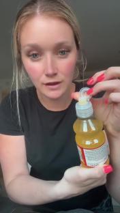 Woman demonstrating a child's drink bottle with a potentially hazardous design.