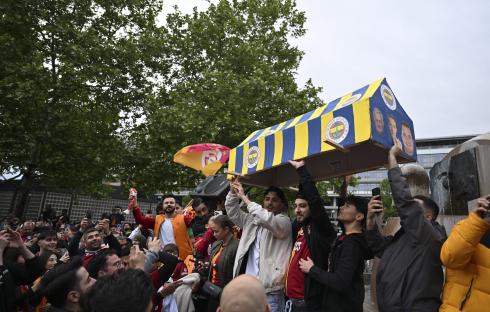 Galatasaray fans celebrating their Turkish Super Lig title victory, carrying a mock FenerbahÃ§e coffin.