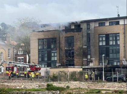 Firefighters at a fire-damaged apartment building.