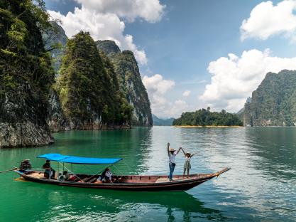 Couple celebrating on a boat tour in Khao Sok National Park, Thailand.