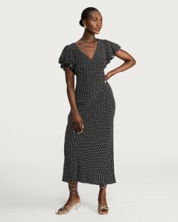 Woman in black and white polka dot midi dress.