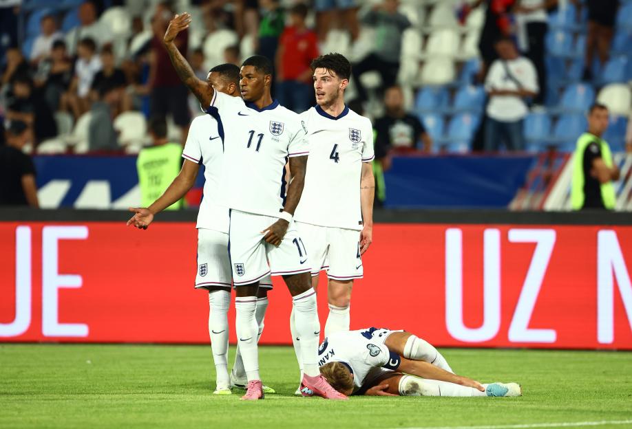 Marcus Rashford of England signaling for medical attention for an injured Harry Kane.