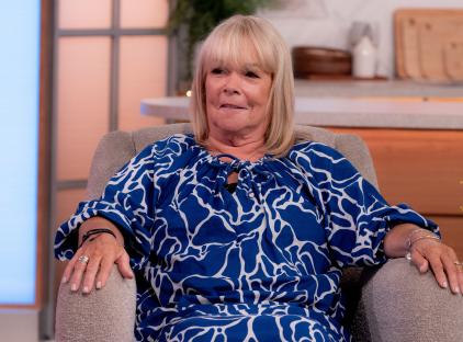 a woman in a blue and white dress sits in a chair