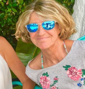 Woman wearing blue sunglasses.
