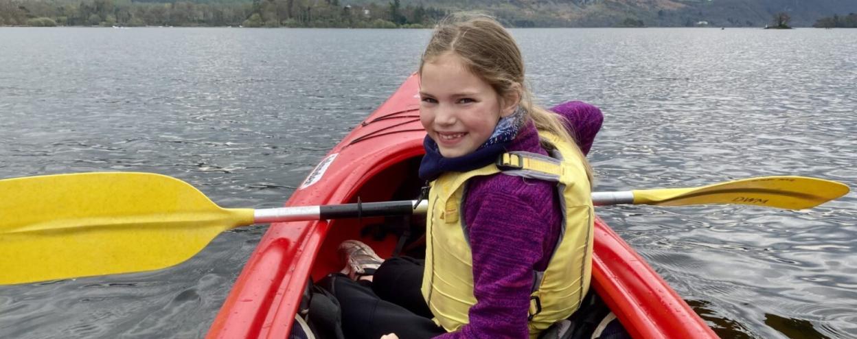 Emily Smith in a red kayak on a lake.