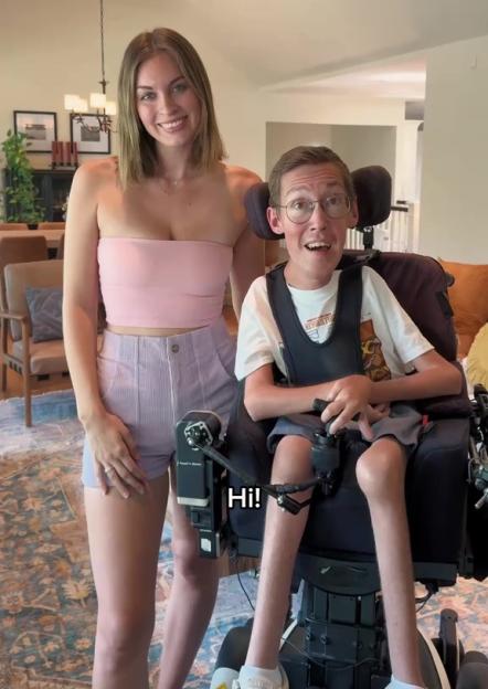 Woman standing behind a man in a wheelchair.