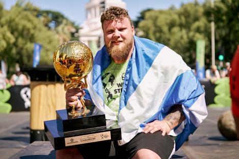 Tom Stoltman, World's Strongest Man 2022, holding his trophy.
