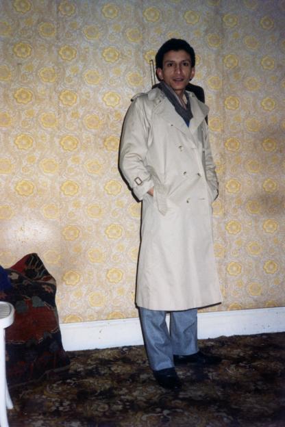 Photo of a man in a beige trench coat.