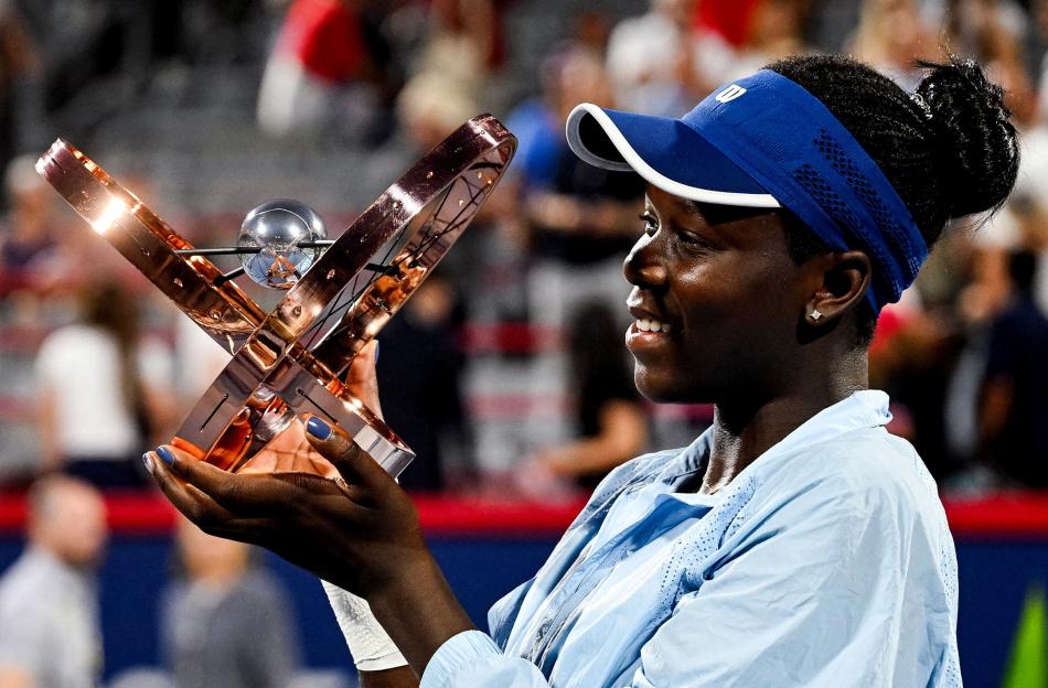Victoria Mboko holding a tennis tournament trophy.