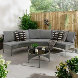 Grey curved outdoor sofa set with coffee table.