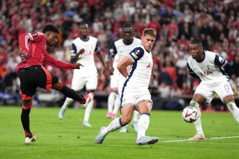 Amad Diallo kicks the ball past Micky van de Ven during a soccer match.