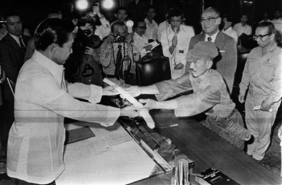 Black and white photo of Hiroo Onoda surrendering his sword to Ferdinand Marcos.
