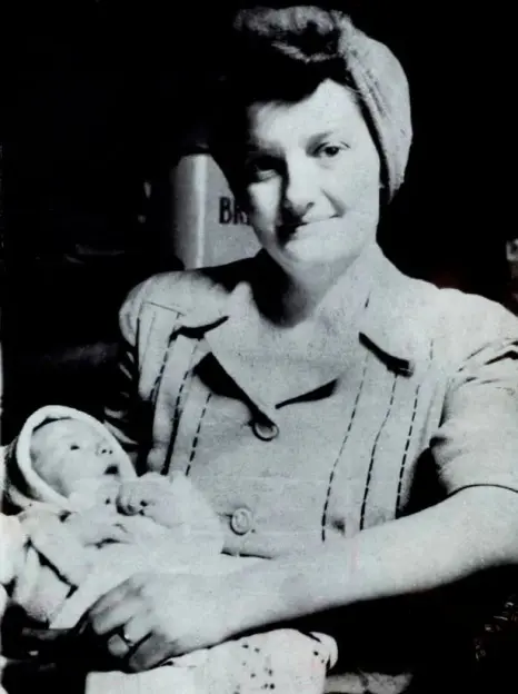Black and white photo of a woman holding a baby.