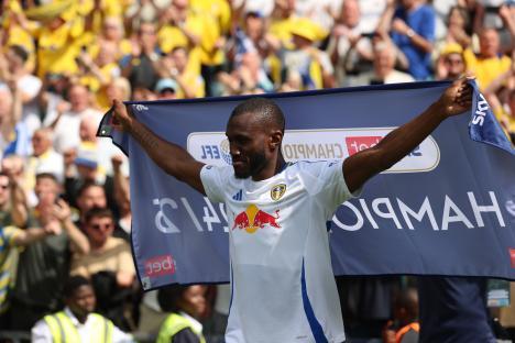 Josuha Guilavogui of Leeds United holding a championship banner.