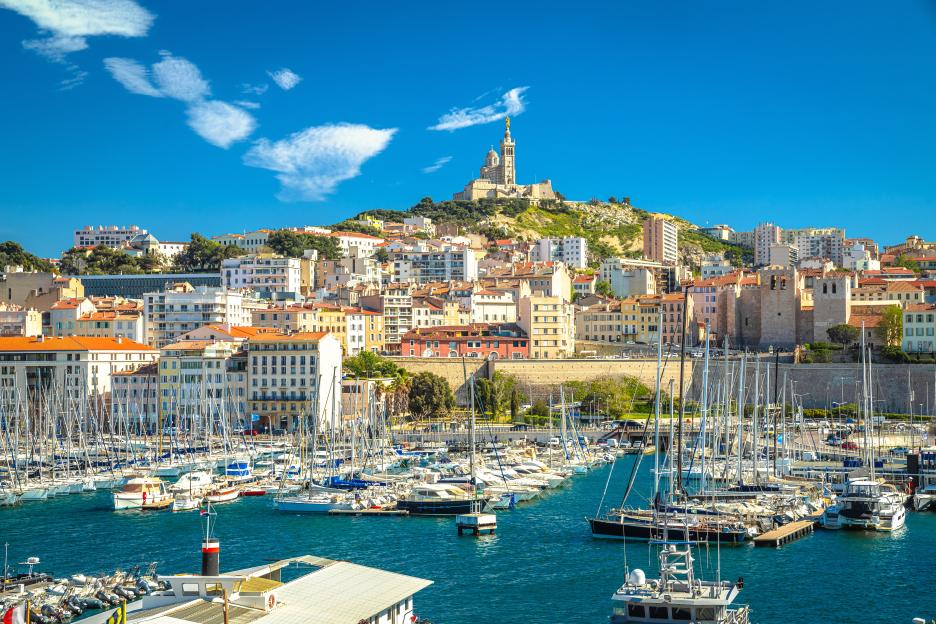 Marseille harbor with Notre-Dame de la Garde basilica on a hill.