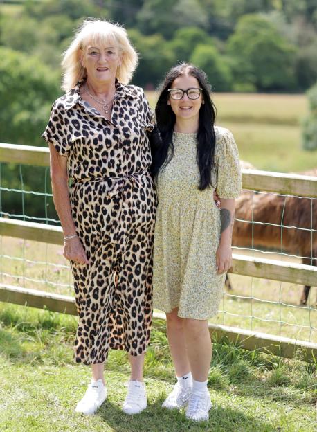 Two women standing together outdoors.