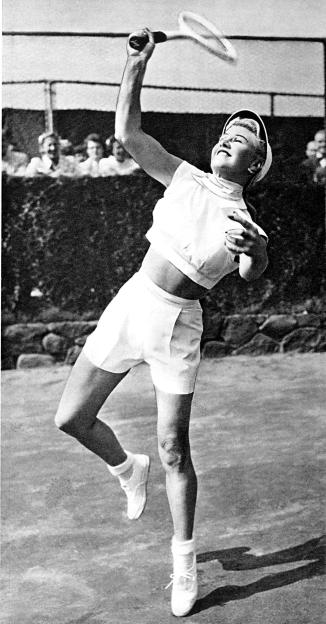 Black and white photo of Ginger Rogers playing tennis.