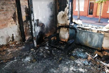 Fire-damaged room with a charred chair.