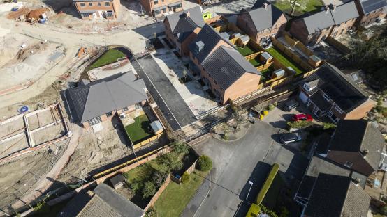 A two-brick-high wall in dispute between a developer and a homeowner, next to a new housing development.