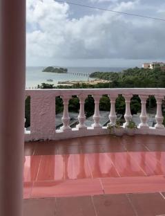 Ocean view from a pink balcony.