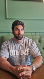 A man sits at a table, looking off to his right.