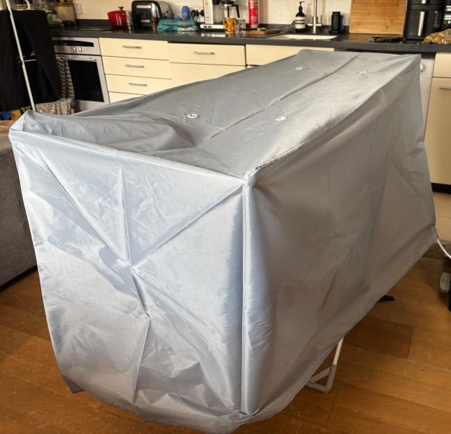 A gray fabric cover over a heated drying rack.