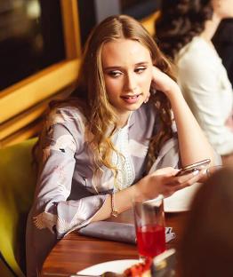 Young woman identified as Vladimir Putin's daughter using her phone.