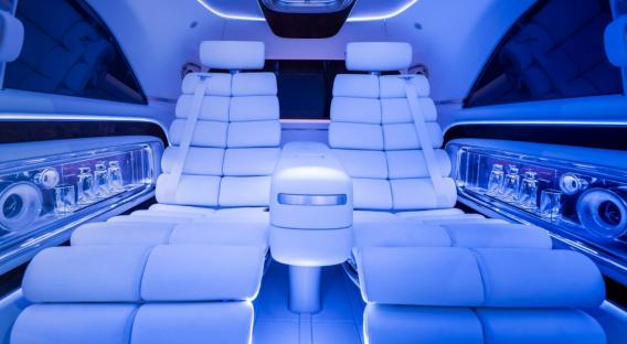 Interior of a Mercedes Vision V Concept vehicle with blue lighting.