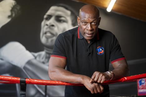Frank Bruno leaning on boxing ring ropes.