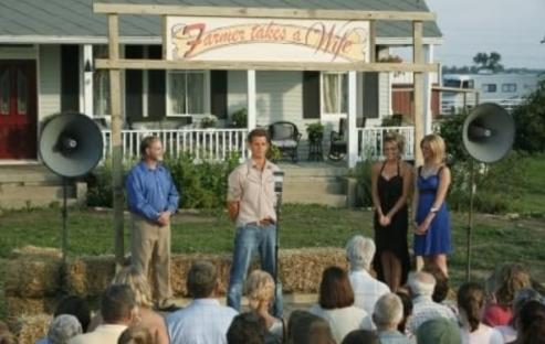 Scene from Farmer Takes a Wife, showing a farmer and two women standing before a crowd.