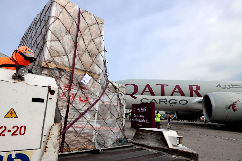 Workers load medical aid onto a Qatar Airways cargo plane.