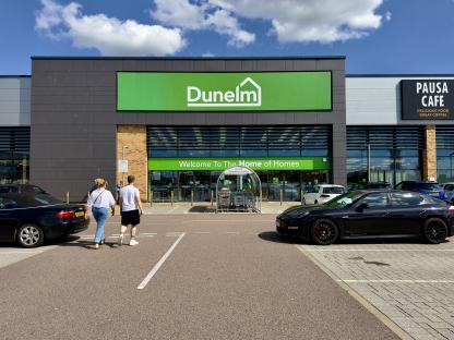 Dunelm store exterior with customers in the parking lot.