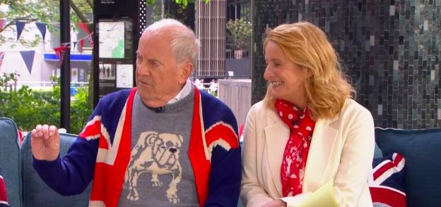 Two people sitting on a couch, one wearing a Union Jack sweater.