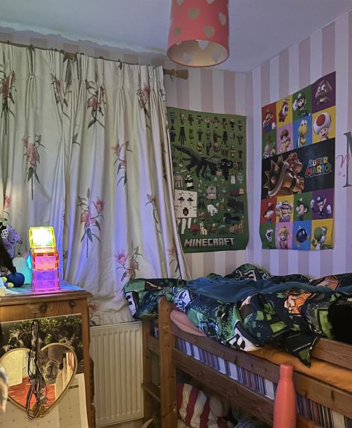 A child's bedroom with a bunk bed, posters of Minecraft and Super Mario characters, and pink striped wallpaper.