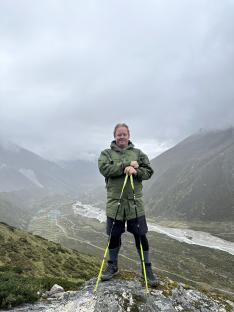 Man hiking in mountains with trekking poles.