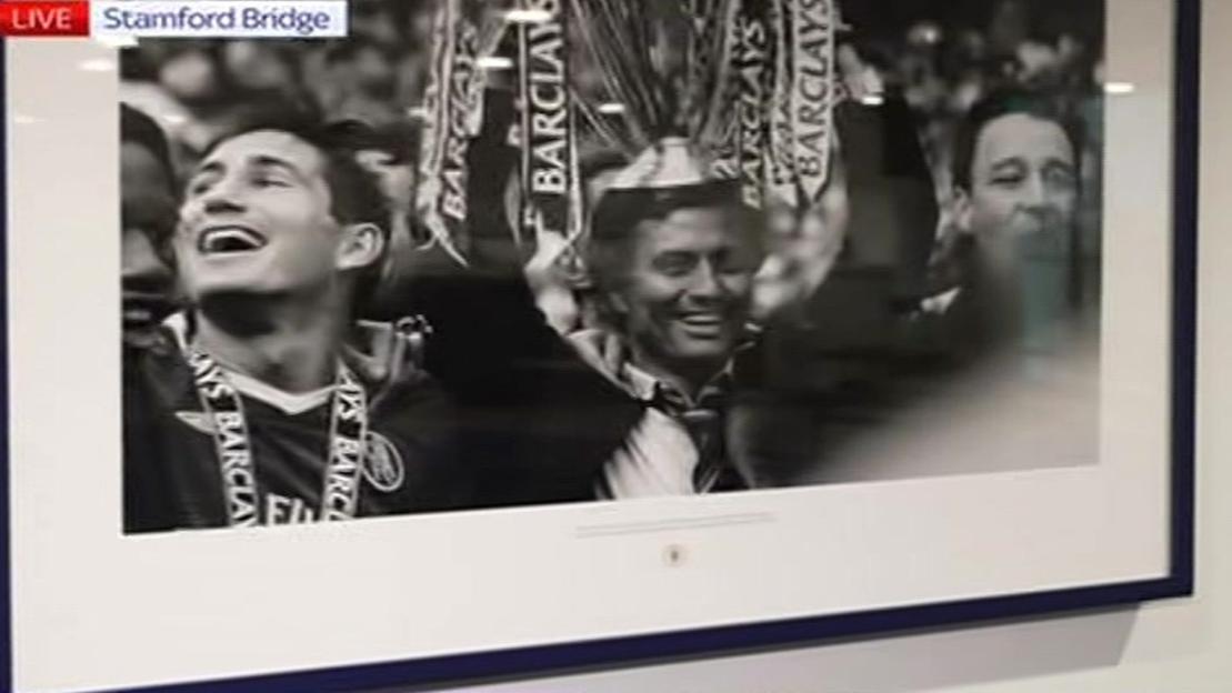 Black and white photo of Chelsea players celebrating with Barclays medals.
