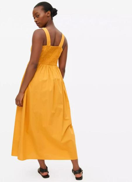 Model wearing a mustard yellow midi dress.