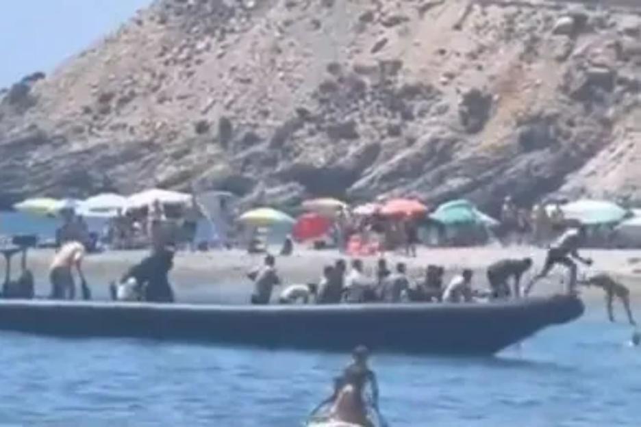 Watch moment migrant boat arrives on Spain hols beach before they are chased & tackled by angry locals