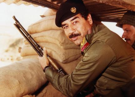 Saddam Hussein holding a rifle.
