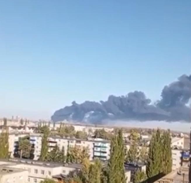 Dark smoke rising from an explosion over a city.