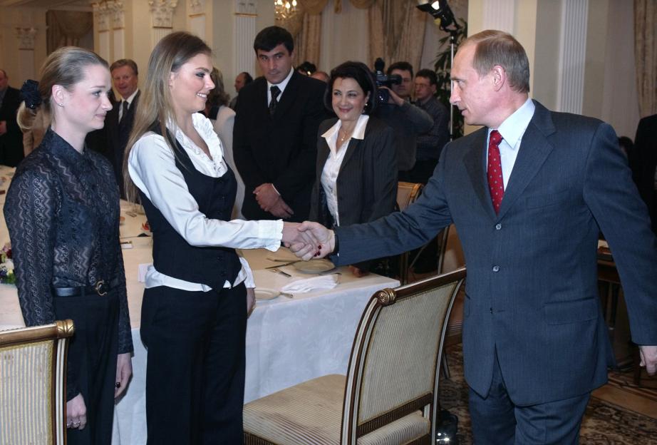 Vladimir Putin shaking hands with Alina Kabayeva and Svetlana Khorkina.