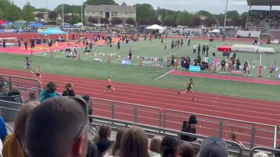 Track athletes running on a track during a race.