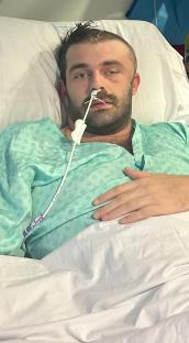 Man in hospital bed with nasal cannula.