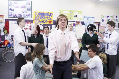 Mr. G from Summer Heights High surrounded by students.