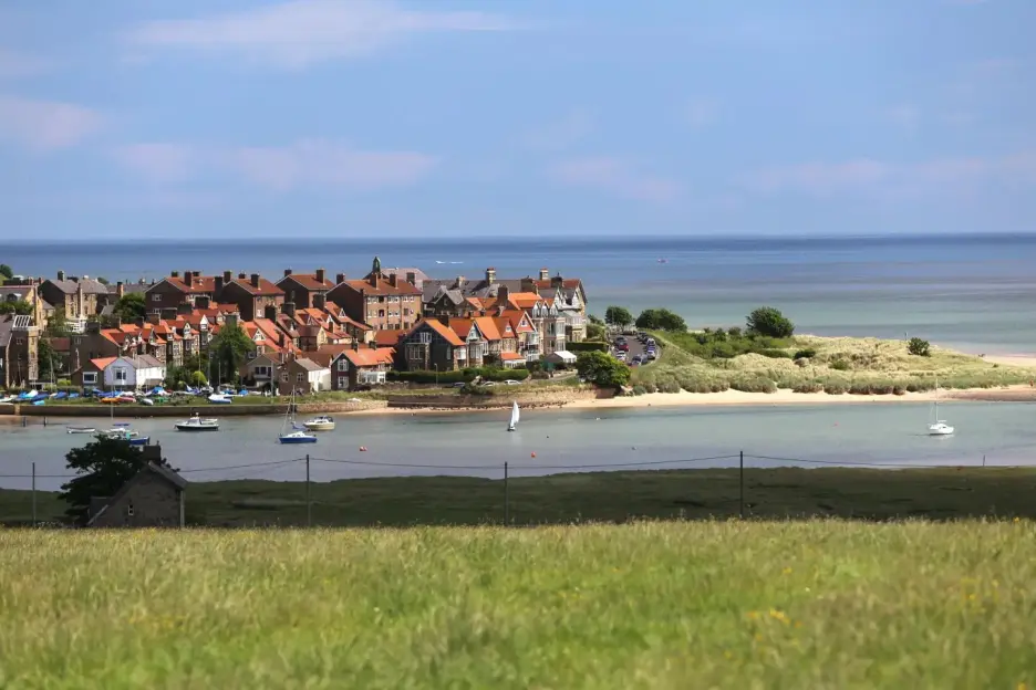 Coastal town with boats and sandy beach.