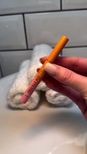 Brown freckle pen held in hand.