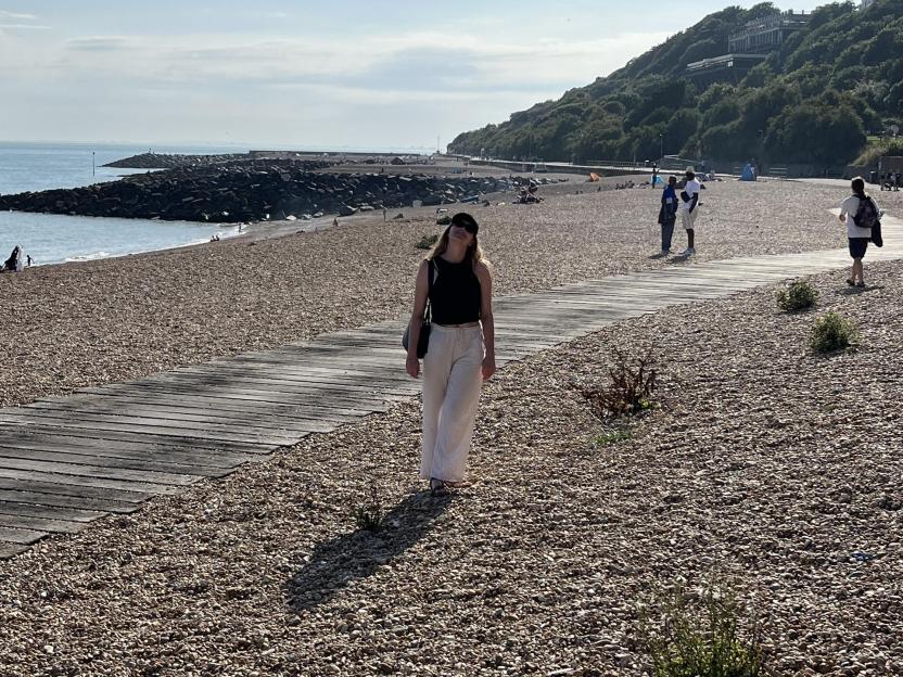 Woman walking on a boardwalk at the beach.