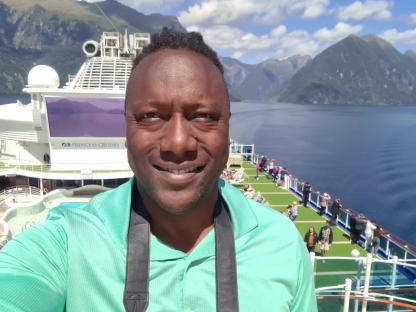 Man on a Princess Cruises ship in a fjord.