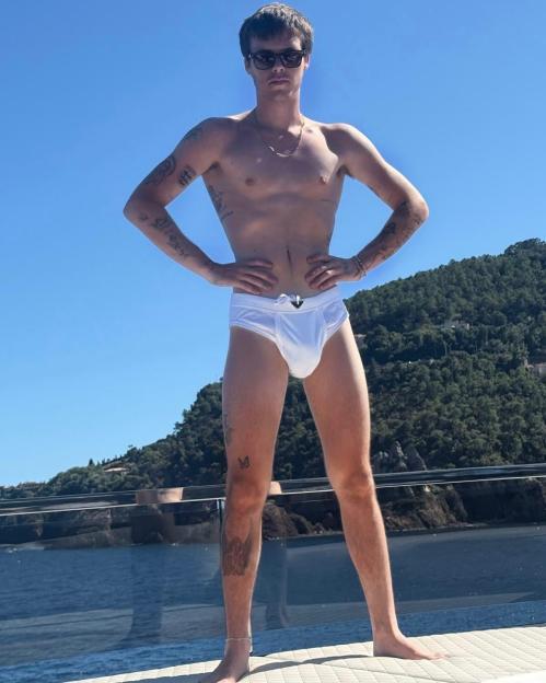 Romeo Beckham in white swim briefs on a boat.