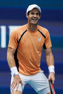 Andy Murray laughing after missing a tennis shot.